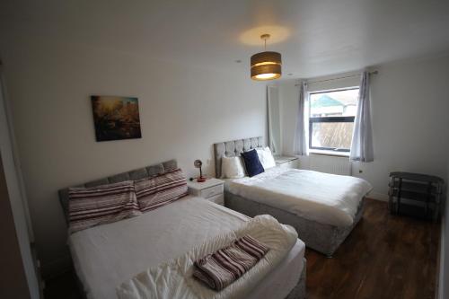 1 dormitorio con 2 camas, sofá y ventana en Garden Court en West Drayton