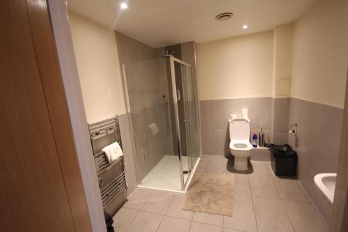a bathroom with a shower and a toilet at Garden Court in West Drayton