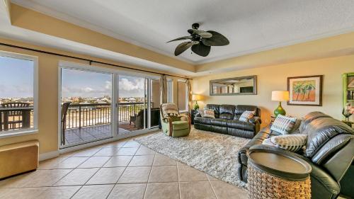a living room with a couch and a ceiling fan at Harbor Landing 203B - Spacious Condo with views of the Harbor and Gulf in Destin