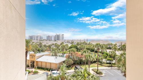 a view of a city with palm trees and buildings at Harbor Landing 203B - Spacious Condo with views of the Harbor and Gulf in Destin