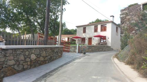 eine Straße mit einer Steinmauer und einem Haus in der Unterkunft Casa do Crego 