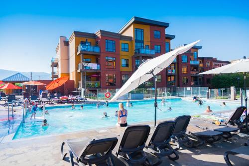 a swimming pool with chairs and people in it at Resort Style Living with Private Lawn and Patio in Kelowna
