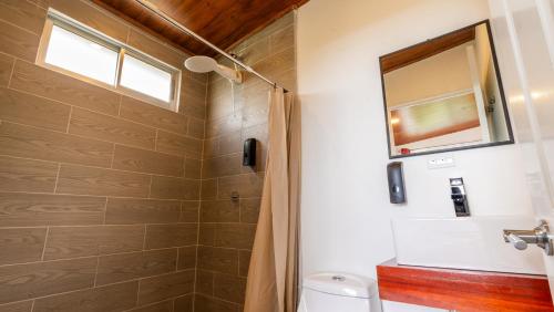 a bathroom with a shower and a toilet and a window at Canto Del Bosque in San Vito