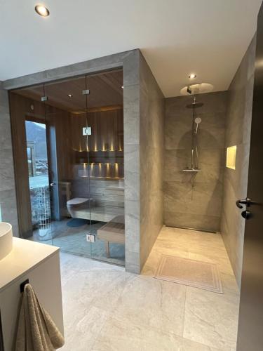 a bathroom with a shower with a tub and a sink at Luxury Lodge with jacuzzi and sauna in Kleppstad