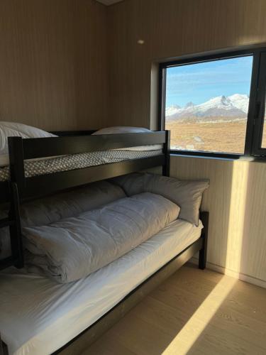 a bed in a room with a large window at Luxury Lodge with jacuzzi and sauna in Kleppstad