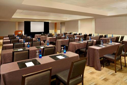 a conference room with tables and chairs and a screen at The Westin Calgary in Calgary