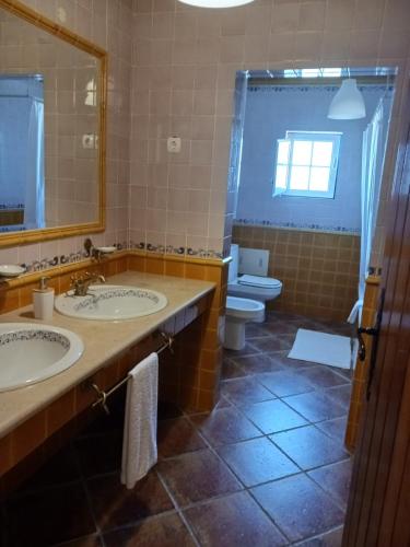 a bathroom with two sinks and a toilet at Monte Novo do Olival in São Cristóvão