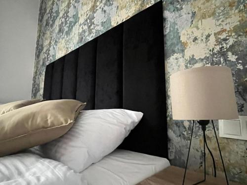 um quarto com uma cama com uma cabeceira preta e um candeeiro em DoriSol em Solec-Zdrój