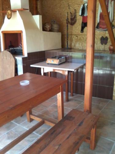 a kitchen with two wooden benches and a table at Къща под наем PETROVA in Cherven