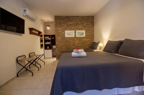 a bedroom with a large bed and a brick wall at Club do Balanço Pousada e Restaurante in Morro de São Paulo