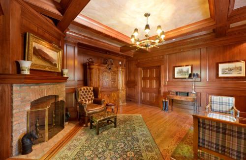 a living room with a fireplace and wooden walls at Hannum House in Skaneateles