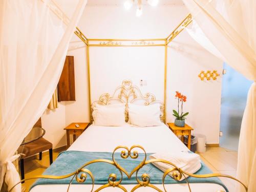 1 dormitorio con 1 cama blanca con dosel en VELINN Hotel Santa Tereza en Ilhabela