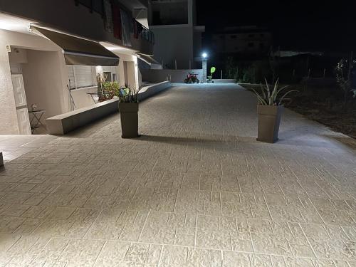an empty walkway with potted plants on the side of a building at Stbs Luxury, Nea Fokea in Nea Fokea