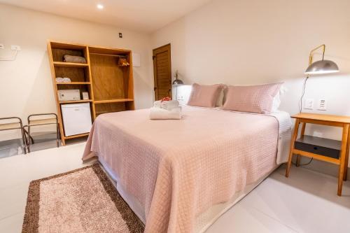 a bedroom with a bed with a pink blanket at Club do Balanço Pousada e Restaurante in Morro de São Paulo