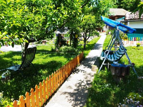 a garden with a playground with a blue swing at Къща под наем PETROVA in Cherven