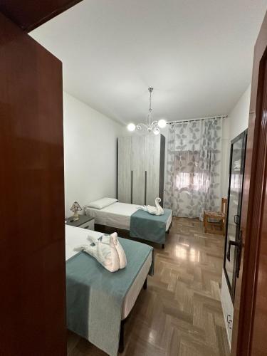 1 dormitorio con 2 camas y lámpara de araña en Casa ANGELA, en Nardò