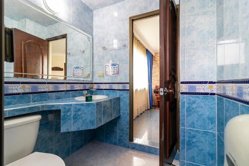 a bathroom with a toilet and a mirror at Lavid Hotel Palacio Real in Bogotá