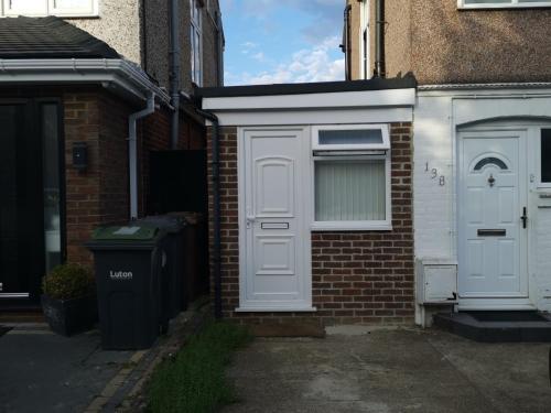 a house with a white door and a window at Argyll Studio Apartment - Luton Airport in Luton