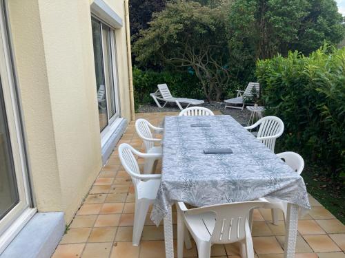 una mesa y sillas en un patio en Maison familiale dans une rue paisible, en Gouville-sur-Mer