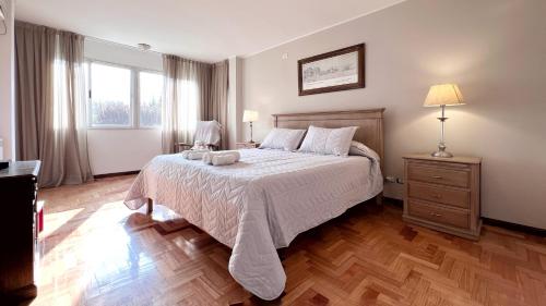 1 dormitorio con 1 cama con colcha blanca en Villa en Mendoza, Argentine en Luján de Cuyo