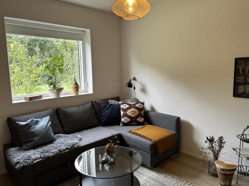 a living room with a couch and a glass table at Casa Jakobsen in Randers