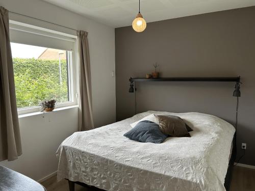a bedroom with a bed with a window and a pillow at Casa Jakobsen in Randers