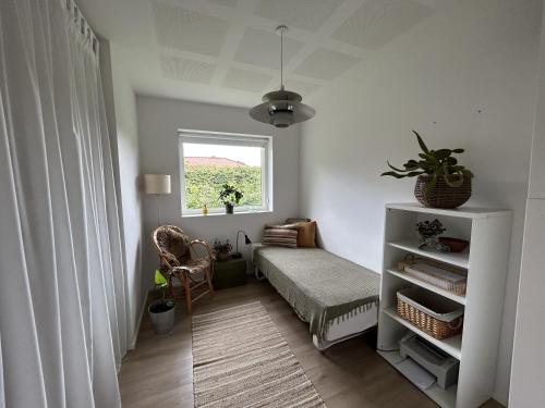 ein Wohnzimmer mit einem Bett und einem Fenster in der Unterkunft Casa Jakobsen in Randers