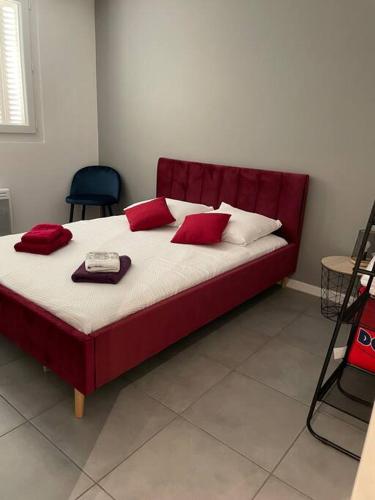 un grand lit avec des oreillers rouges dans l'établissement Logement Rénové - Une Expérience Unique - Wifi Gratuit, à Grenoble