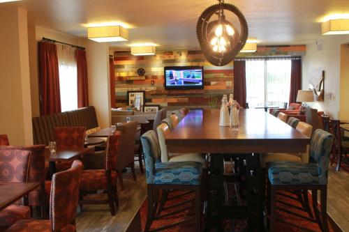 a restaurant with a large wooden table and chairs at Hampton Inn Beaumont in Beaumont