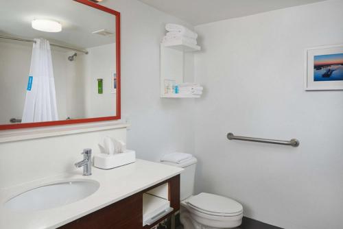 a bathroom with a sink and a toilet and a mirror at Hampton Inn Beaumont in Beaumont