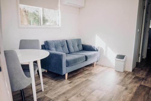a living room with a blue couch and a table at West View Caravanpark in Dubbo