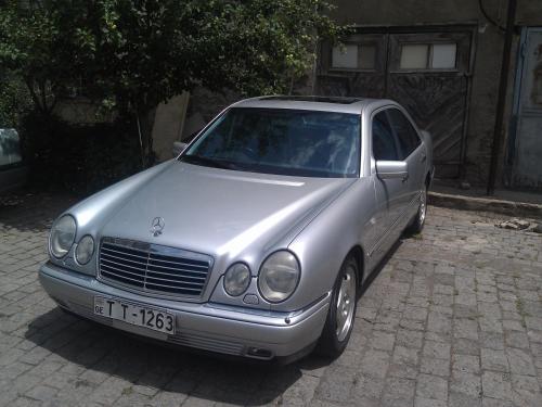 a silver car parked on a brick street at Kutaisi City Heart Apartment in Kutaisi