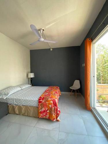- une chambre avec un lit et un ventilateur de plafond dans l'établissement Amplio departamento con alberca, à Playa del Carmen