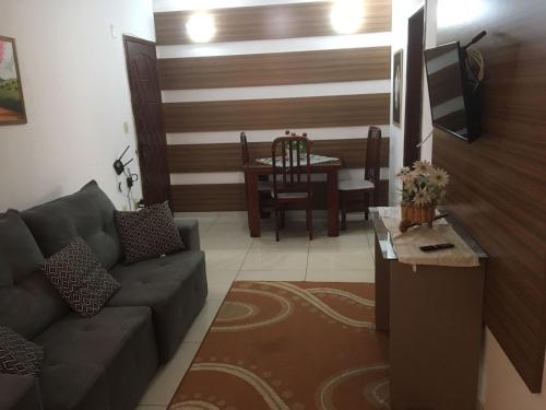 a living room with a couch and a table at Apartamento ao lado Shopping in Campos dos Goytacazes