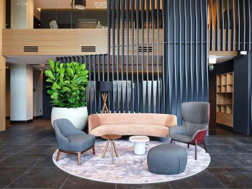 a lobby with chairs and a couch and a table at Radisson Hotel Budapest BudaPart in Budapest