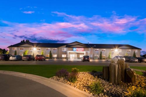 a hotel with cars parked in a parking lot at SureStay Plus Hotel by Best Western Rexburg in Rexburg