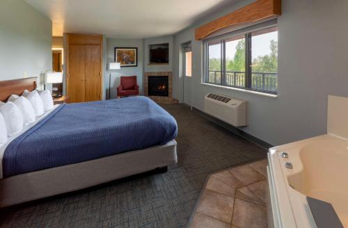 a hotel room with a bed and a fireplace at Black Beach Inn by GrandStay in Silver Bay