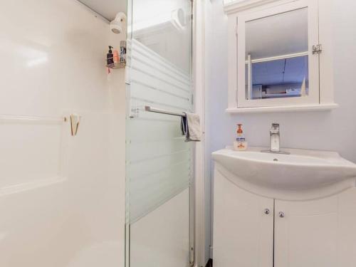 a white bathroom with a sink and a mirror at Cozy Capitol Hill Bungalow - 3BD/2BA Retreat in Burnaby