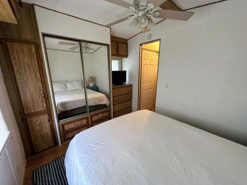 a bedroom with a white bed and a mirror at 15 min to Disney World, Self-check-in, Full Kitchen in Kissimmee