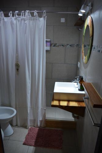 a bathroom with a white shower curtain and a sink at Inti. in Saladillo