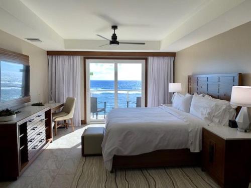 um quarto com uma cama e uma secretária com vista para o oceano em Beachfront 3 Bedroom Villa em Dawn Beach