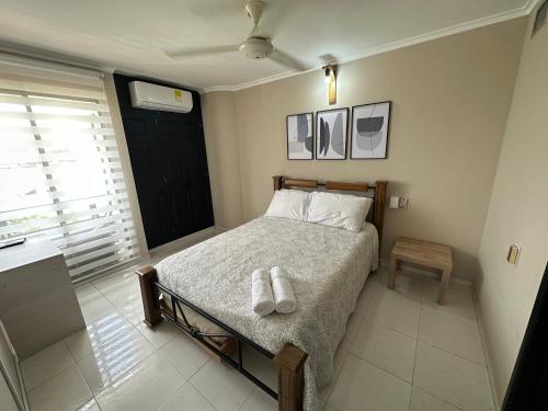a bedroom with a bed with two towels on it at Hermoso Apartamento con Piscina 1 Habitacion PR32 in Montería