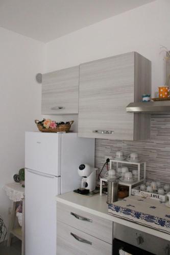 a kitchen with white cabinets and a white refrigerator at B&b la Casa dei Nonni in Silvi Paese