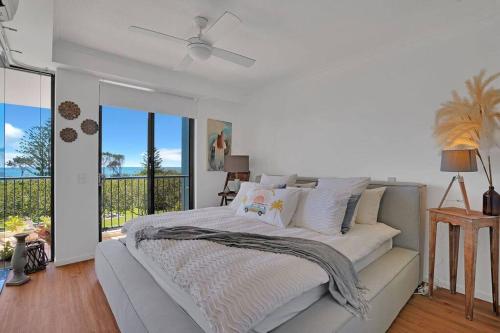 a white bedroom with a bed and a large window at Luxury Personified on Alex - Ocean Views 2 Bed 2 Bath in Alexandra Headland
