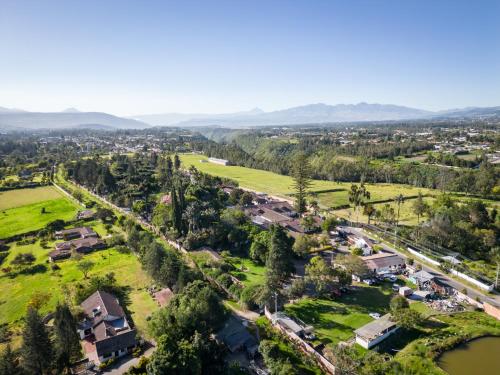 an aerial view of a village with houses and a river at San Jose de Puembo Quito Airport, an Ascend Collection Hotel in Puembo