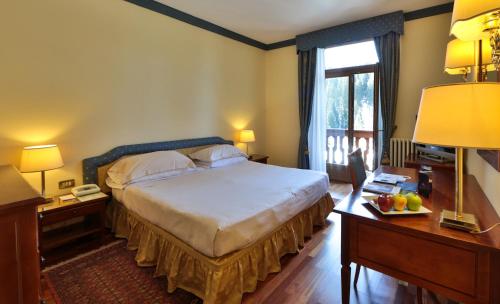 a bedroom with a large bed and a window at TH Madonna di Campiglio | Golf Hotel in Madonna di Campiglio
