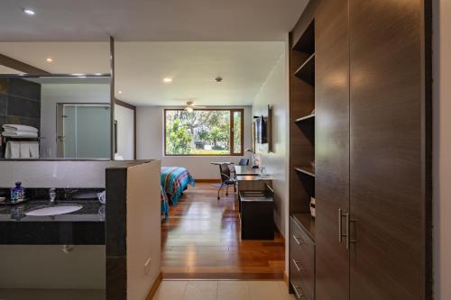 a bathroom with a sink and a desk in a room at San Jose de Puembo Quito Airport, an Ascend Collection Hotel in Puembo