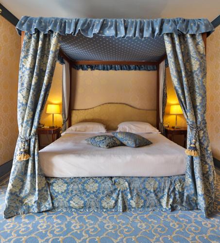 a bed with a canopy with two pillows on it at TH Madonna di Campiglio | Golf Hotel in Madonna di Campiglio