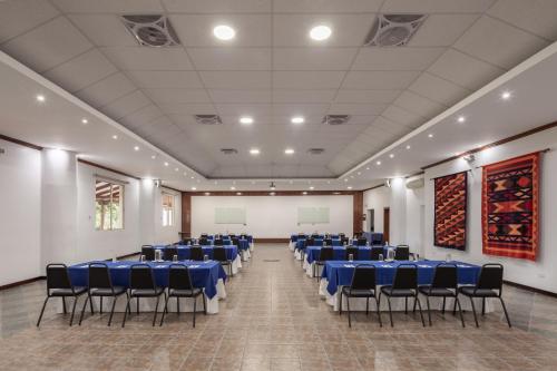 a large room with blue tables and chairs in it at San Jose de Puembo Quito Airport, an Ascend Collection Hotel in Puembo