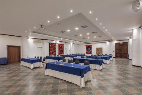 a banquet hall with blue and white tables and chairs at San Jose de Puembo Quito Airport, an Ascend Collection Hotel in Puembo